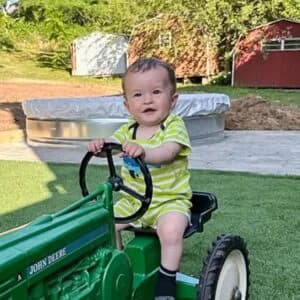 exterior of artificial turf foundation with kid on tractor
