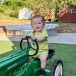 exterior of artificial turf foundation with kid on tractor