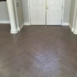 patterned dark hardwood floors in entry way with white doors