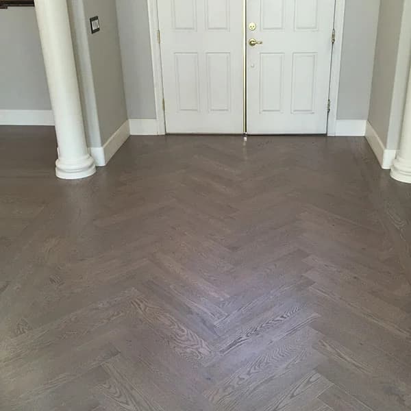 patterned dark hardwood floors in entry way with white doors