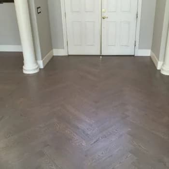 patterned dark hardwood floors in entry way with white doors