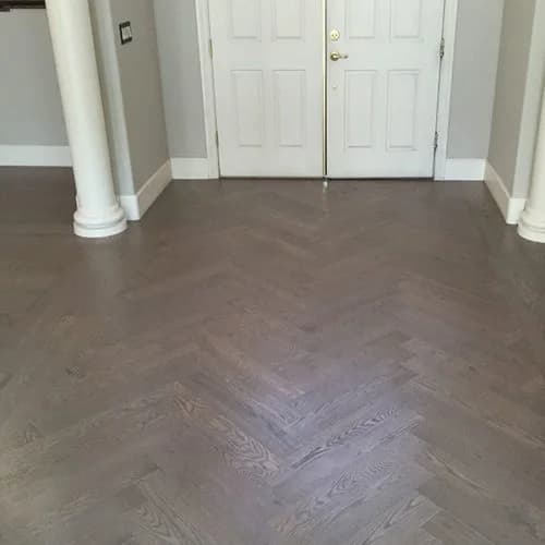 patterned dark hardwood floors in entry way with white doors