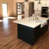 new hardwood floors in updated kitchen with black cupboards and white countertops