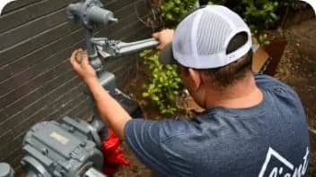worker using wrench to tighten gas plumbing pipes