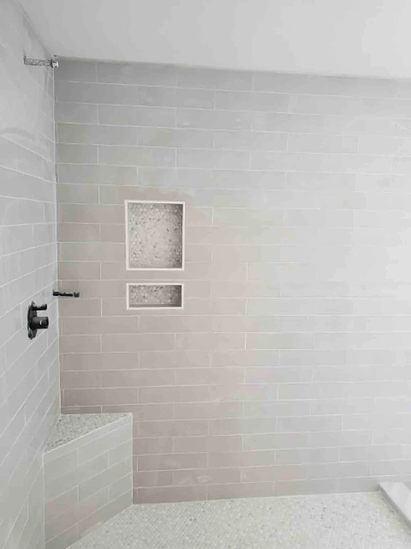 A shower with white tiling, installed by Footprints Floors.