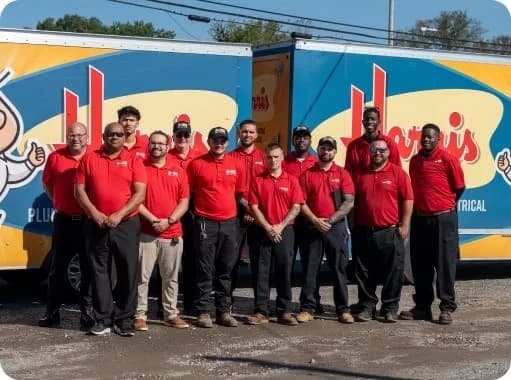 A group of Harris employees pose in front of two company trucks.