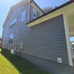 A close up of a blue house with new fiber cement lap siding.