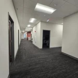 A commercial building in Cary, NC, with an interior corridor showcasing freshly painted off-white walls.