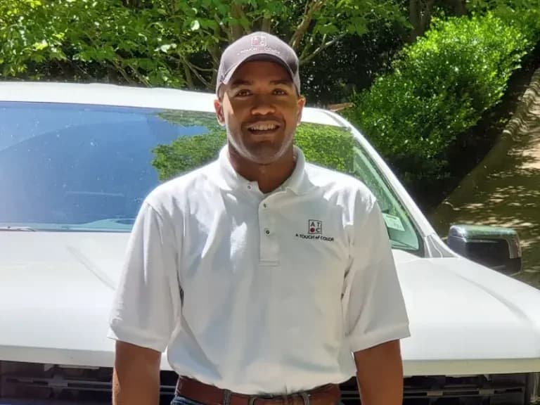 Raleigh painting contractor and home improvement specialist Courtney Ray in company uniform with professional service vehicle.