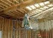 worker on ladder applying spray foam to ceiling