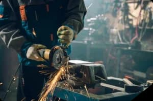 Person using angle grinder with sparks flying.