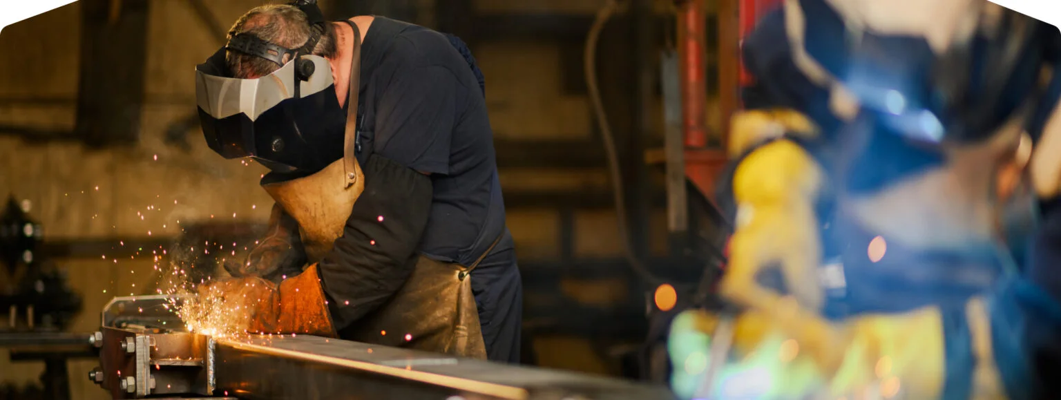 Welder sparks welding metal beam.