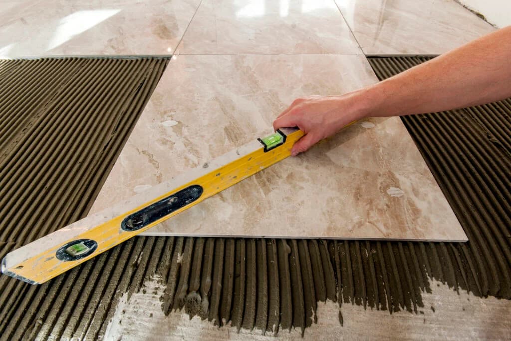 Ceramic tiles and tools for tiler. Floor tiles installation. Home improvement, renovation - ceramic tile floor adhesive, mortar, level