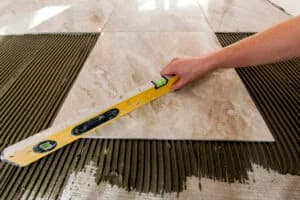 Ceramic tiles and tools for tiler. Floor tiles installation. Home improvement, renovation - ceramic tile floor adhesive, mortar, level