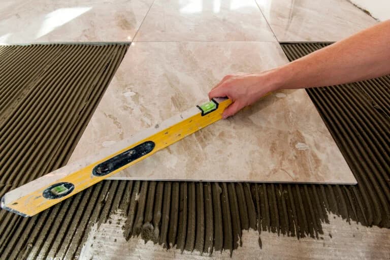 Ceramic tiles and tools for tiler. Floor tiles installation. Home improvement, renovation - ceramic tile floor adhesive, mortar, level