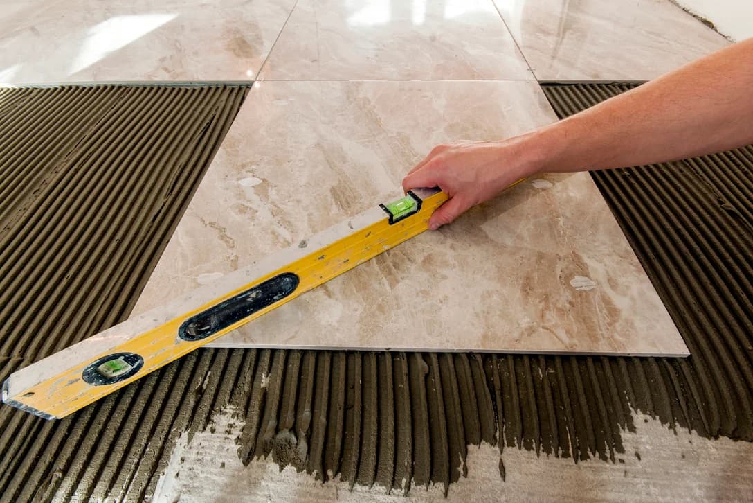 Ceramic tiles and tools for tiler. Floor tiles installation. Home improvement, renovation - ceramic tile floor adhesive, mortar, level