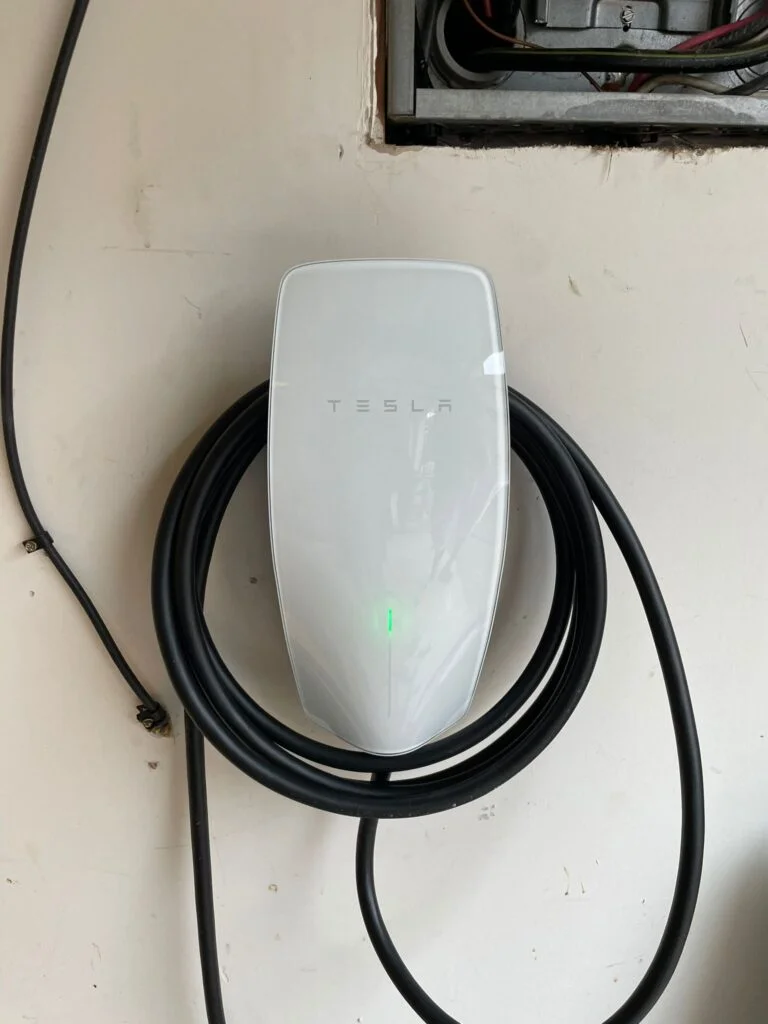 Tesla electric car charging at a home charging station