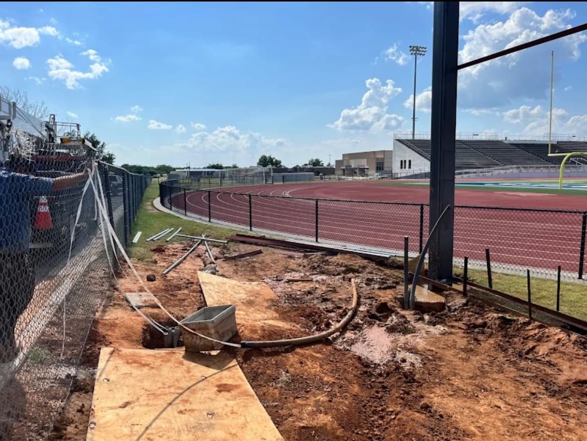 Trinity Boring Solutions directional boring stadium track field Oklahoma City clear blue sky underground utility installation