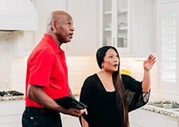 Mr. Handyman speaking with customer in a kitchen.