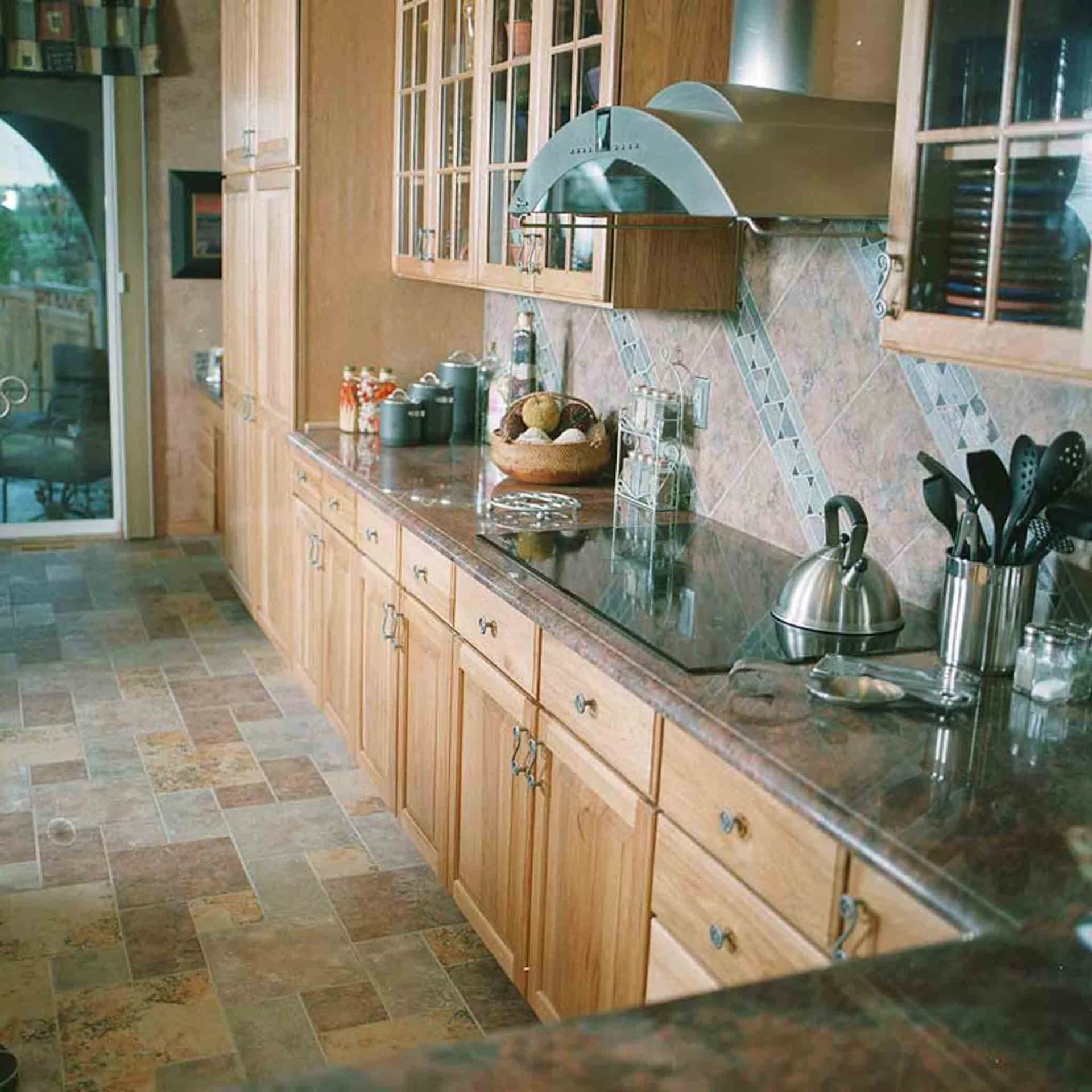 A kitchen with tile flooring and backsplash, installed by Footprints Floors.
