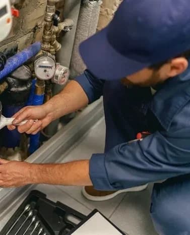 Professional plumber repairing water supply system at home uses a special tools