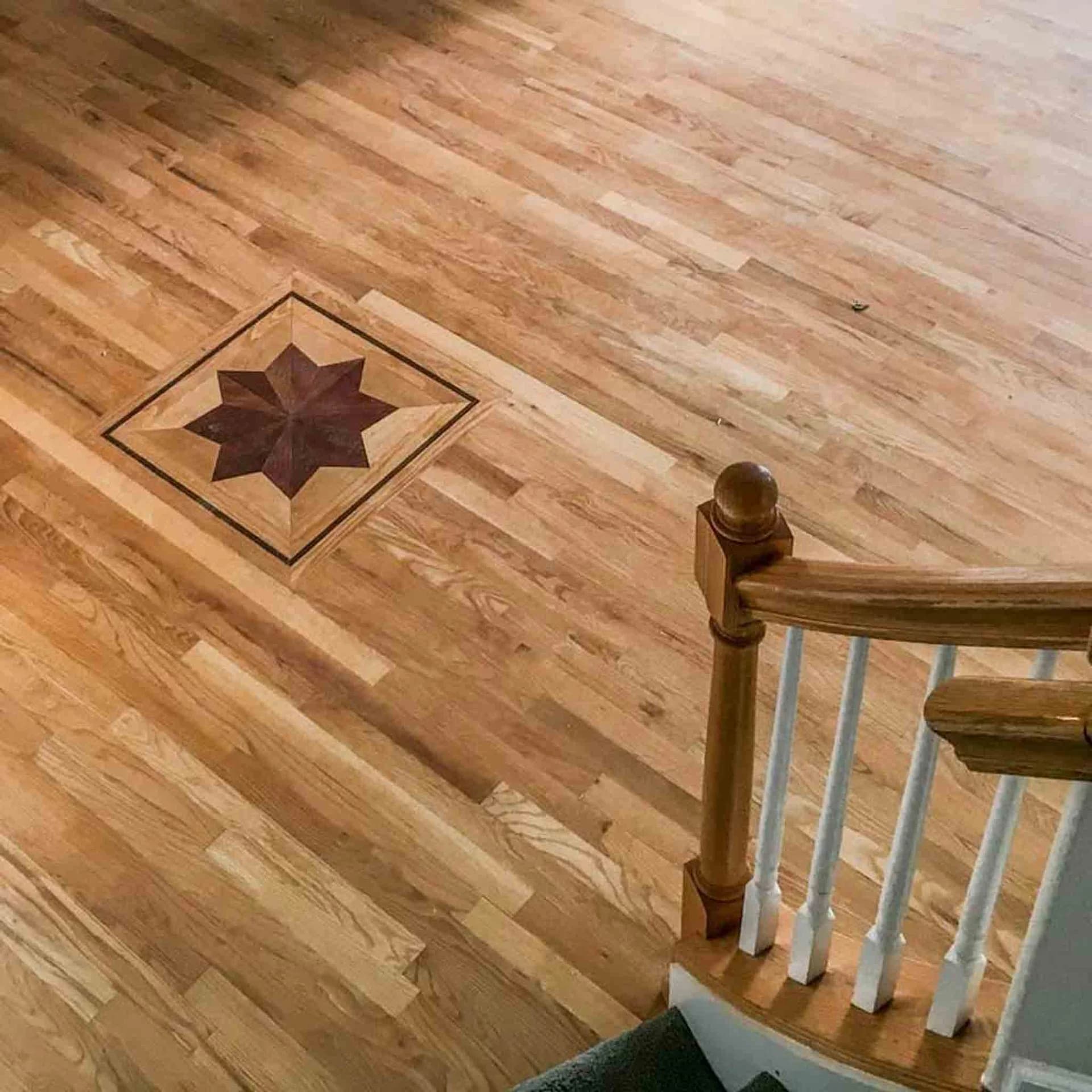 A wood floor with a star design, done by Footprints Floors.
