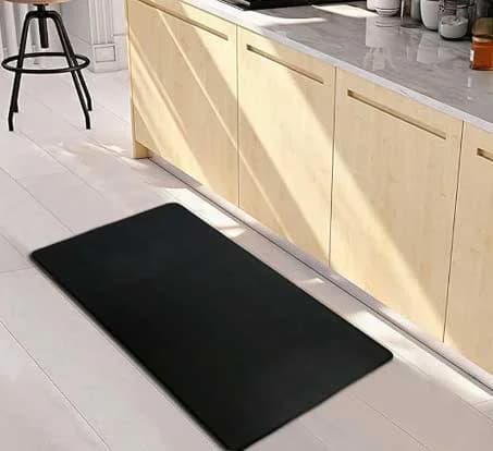 Black kitchen mat placed on tile floor in residential kitchen