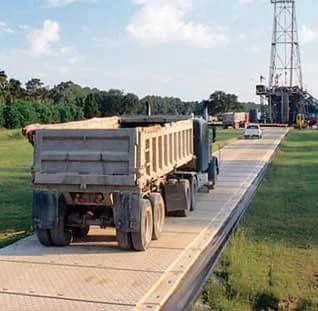 Temporary road mats supporting heavy equipment on a construction site