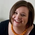 Smiling woman with a short haircut and orange necklace, representing customer satisfaction for American Foundation Specialists' foundation repair services.