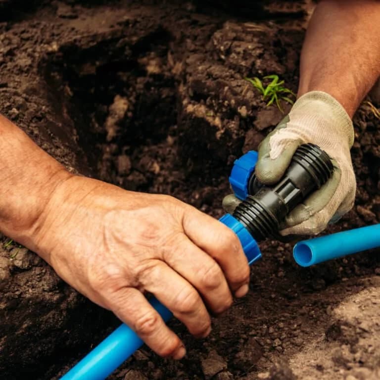 A technician conducts an irrigation system repair.