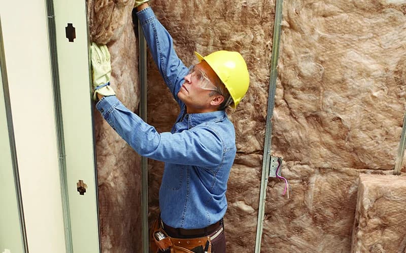 Man installing insulation in central New Mexico