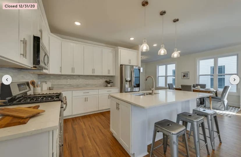 Professional painter spray-applying white finish to kitchen cabinet doors in Nashville, TN