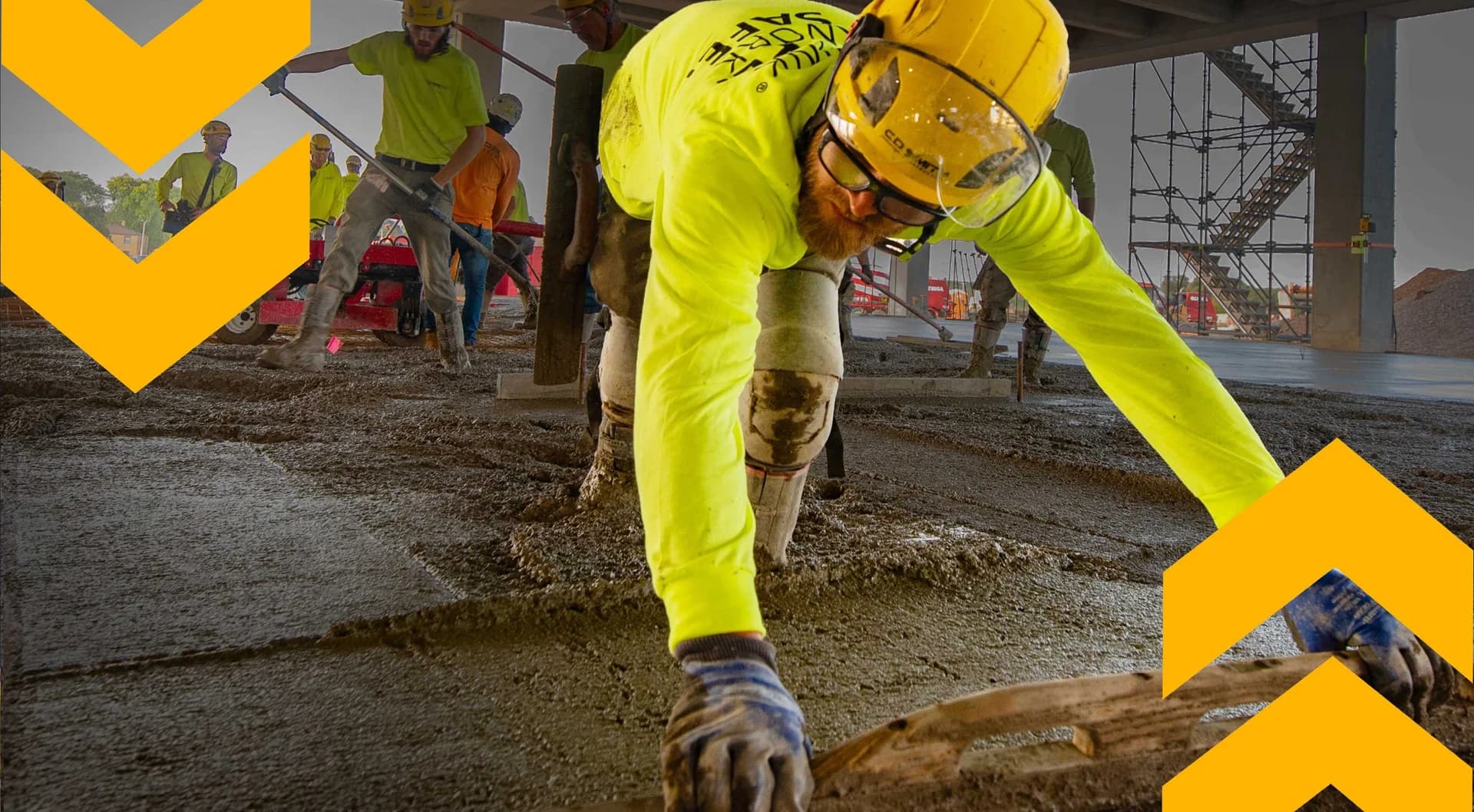 Concrete worker in high-visibility PPE at a construction site, representing C.D. Smith's expertise in building solutions.