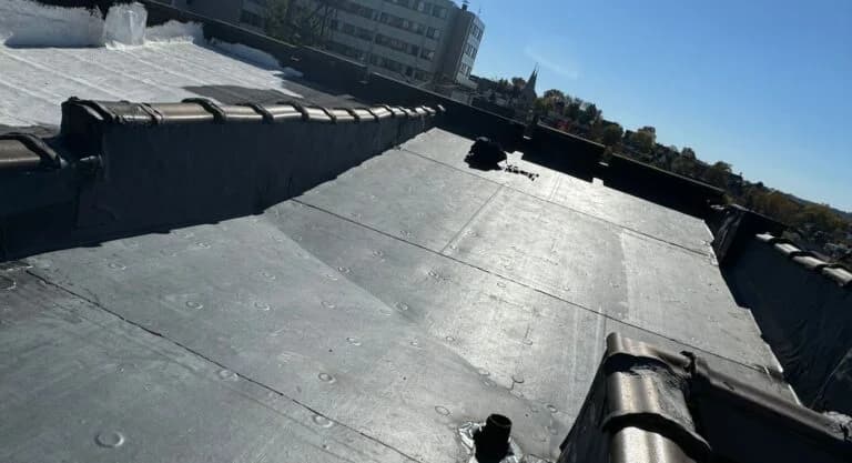 Rubber roof installation showcasing flat roofing surface and adjacent roofing details in Pittsburgh.