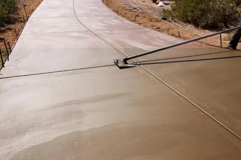 smoothing out a stained concrete driveway