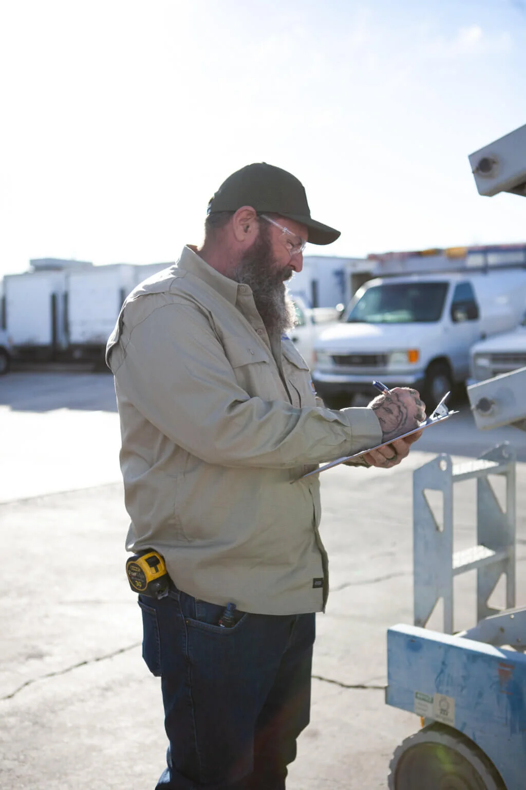 Commercial electrician inspecting an electrical installation project and taking notes on a clipboard