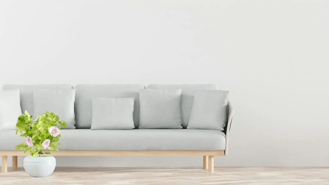 A plant and sofa complement the minimalist flooring.