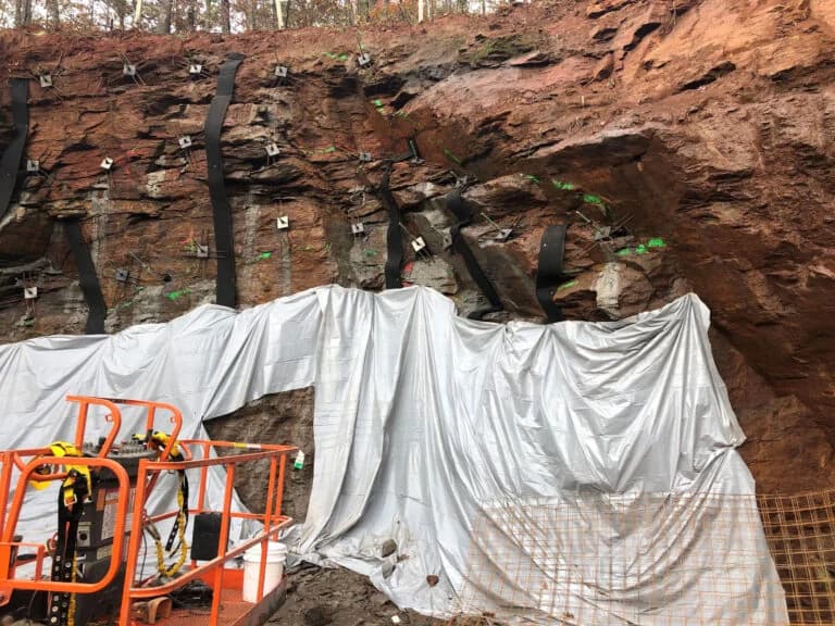 Slope with rock anchors for retaining wall or structural repair.