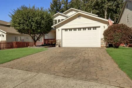 Stamped concrete driveway in front of white house