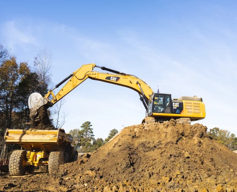 machine loading dirt into truck