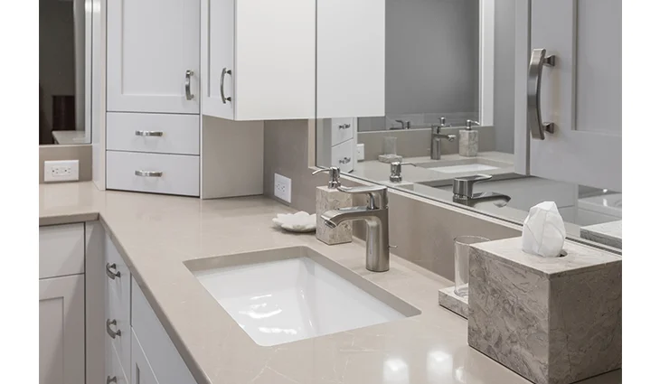 Renovated bathroom with a mirror and tan sink countertops