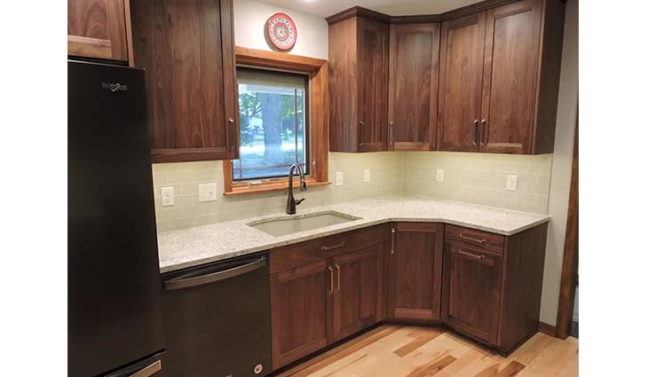 New kitchen with white granite countertops and a black dishwasher