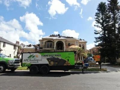 Roofing truck with APC Roofing LLC branding and contact number.
