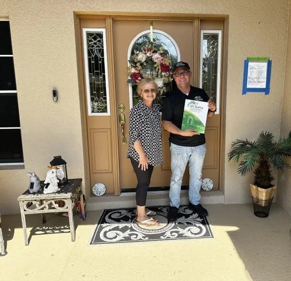 Homeowner and roofer standing at front door with inspection report.