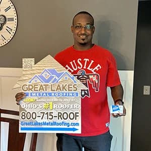 Black man on a red t-shirt holding a Great Lakes Home Remodeling sign