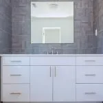 Grey stone pattern tiled contemporary bathroom interior design with minimal natural wood furniture details dominate neutral colors. Interior design of a bathroom restroom interior design