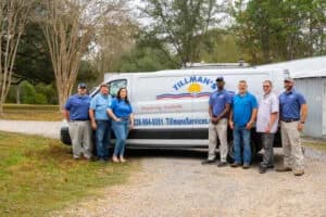 Team of Tillman's heating service professionals standing next to branded service van in Gulfport, MS, showcasing expertise in heating solutions and customer service.