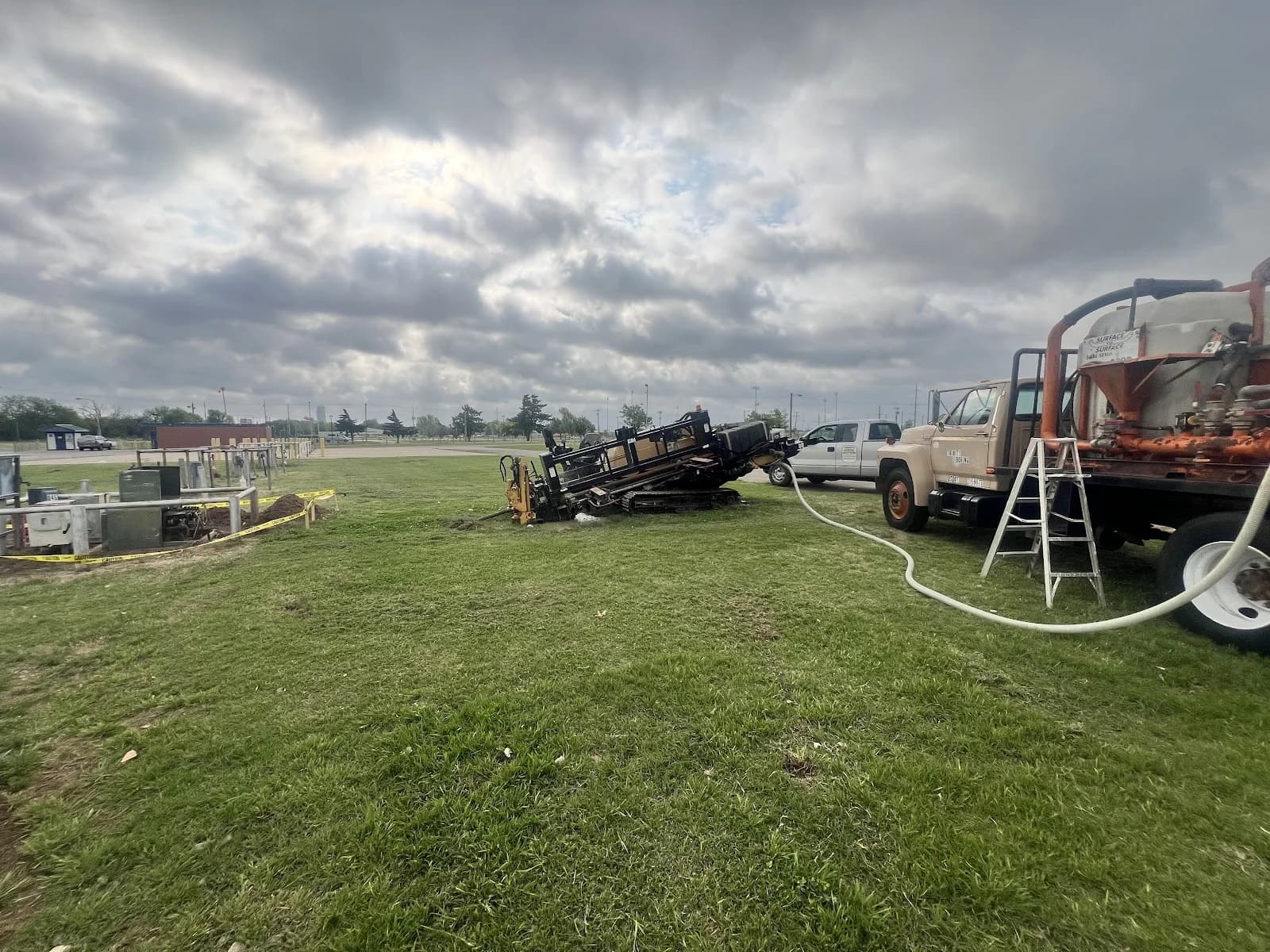 Trinity Boring Solutions HDD boring rig vacuum truck Oklahoma City open field utility bore storm clouds large commercial project