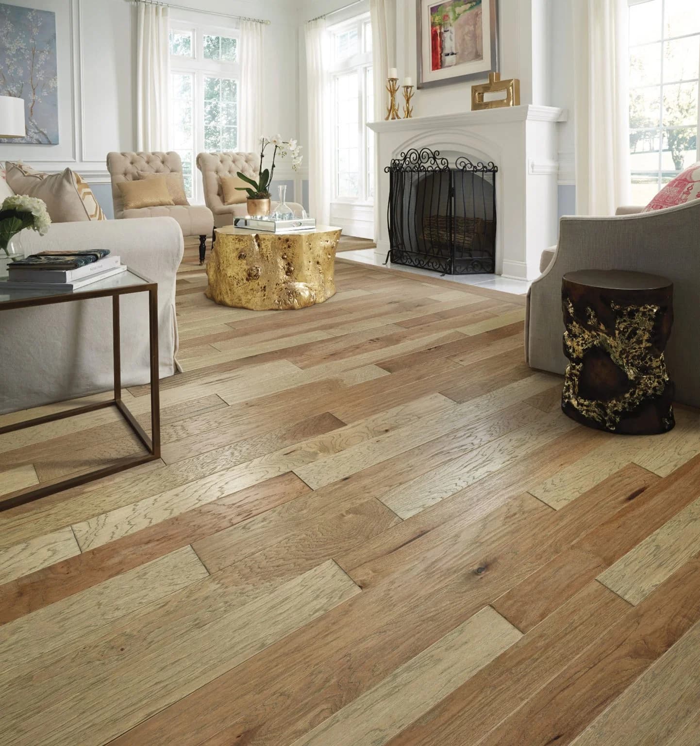 light hue of a brown hardwood floor. It is a living room with a fireplace, comfy furniture, and a white paint job