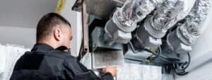 Male technician installing ductwork.
